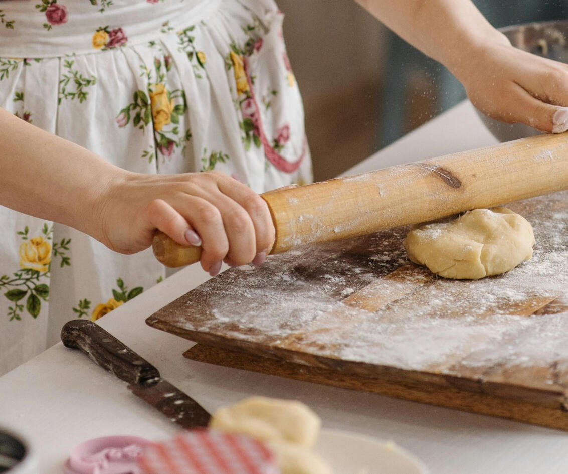 close up of woman rolling dough